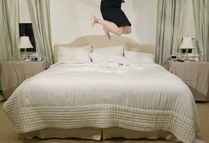Woman jumping on bed