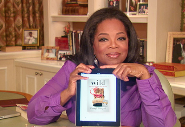 Oprah holding iPad with the book Wild by Cheryl Strayed