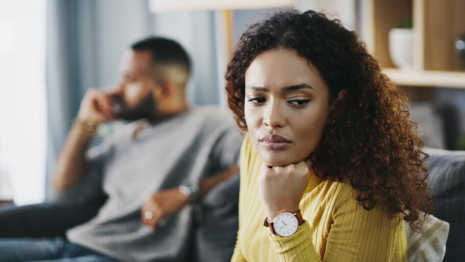 Woman deep in thought with partner in background