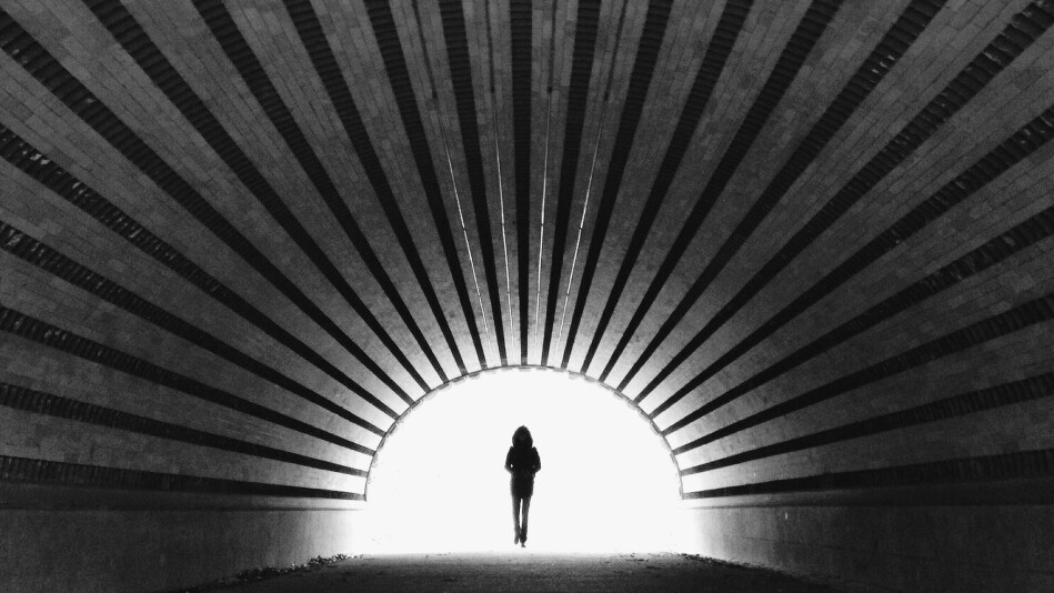 woman walking through a tunnel