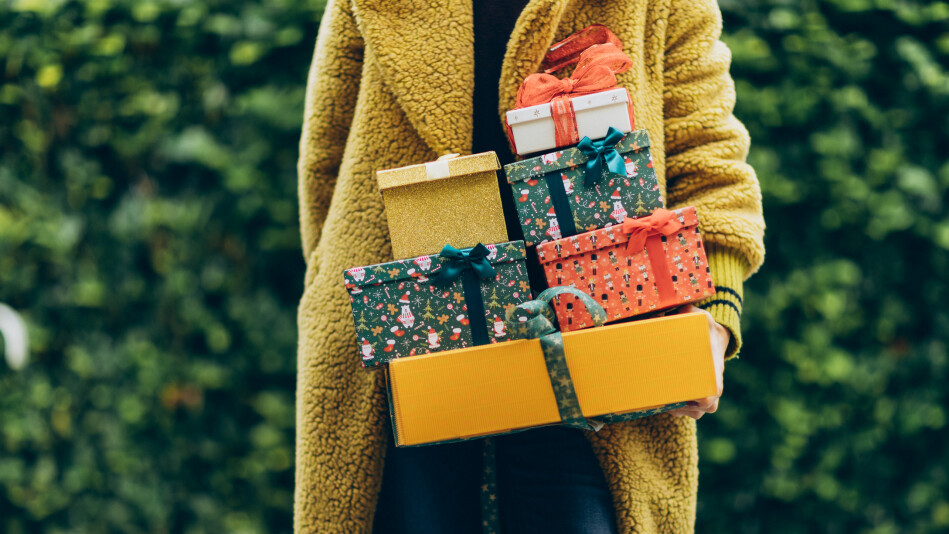 woman holding stack of wrapped gift boxes