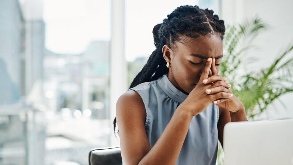 young Black woman stressed out at office job