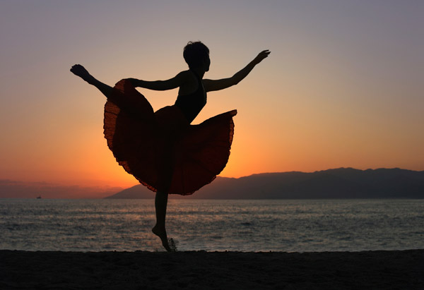 Ballet dancer on the beach at sunset