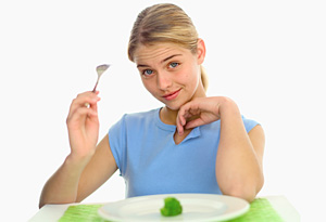 Teen eating broccoli