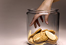 Woman with hand in cookie jar.